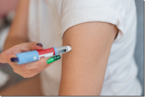 Woman injects herself with the drug Ozempic anti-diabetes pen into her arm at home. Weight loss and decreased blood sugar, concept idea.  injector dosing pen for subcutaneous injection